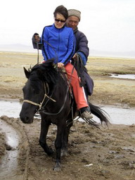 Mongolian horseman crossing muddy waters